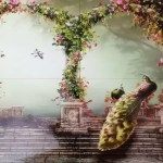 A multi-tile sublimation print showcasing a lush garden scene with stone pillars, floral arches, flying birds, and peacocks on stone steps, highlighted by the text "Vibrant colors".