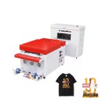 FJK Sublimation industrial printer and curing equipment setup displayed alongside a black t-shirt and graphic sheet featuring Marvel Studios branding.