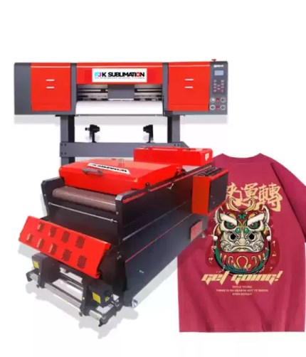 Industrial wide-format sublimation printer and matching powder shaker/curing dryer unit shown with a finished maroon t-shirt featuring a detailed Japanese guardian demon graphic and typography.