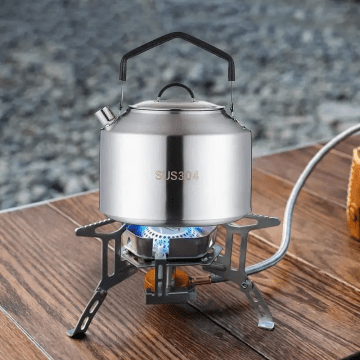 Precise stream of water pouring from a camping coffee kettle into a metal tableware mug.
