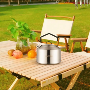 A 1.5L outdoor coffee kettle sitting on a wooden picnic table during a summer camping trip.