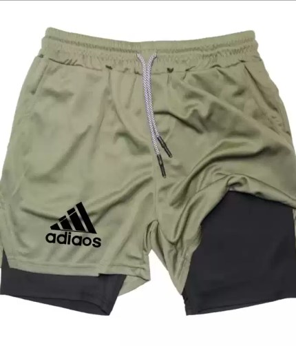 Olive green athletic shorts with a built-in black compression liner and adjustable drawstring