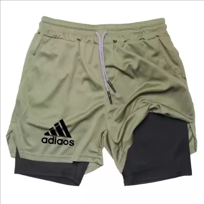 Olive green athletic shorts with a built-in black compression liner and adjustable drawstring