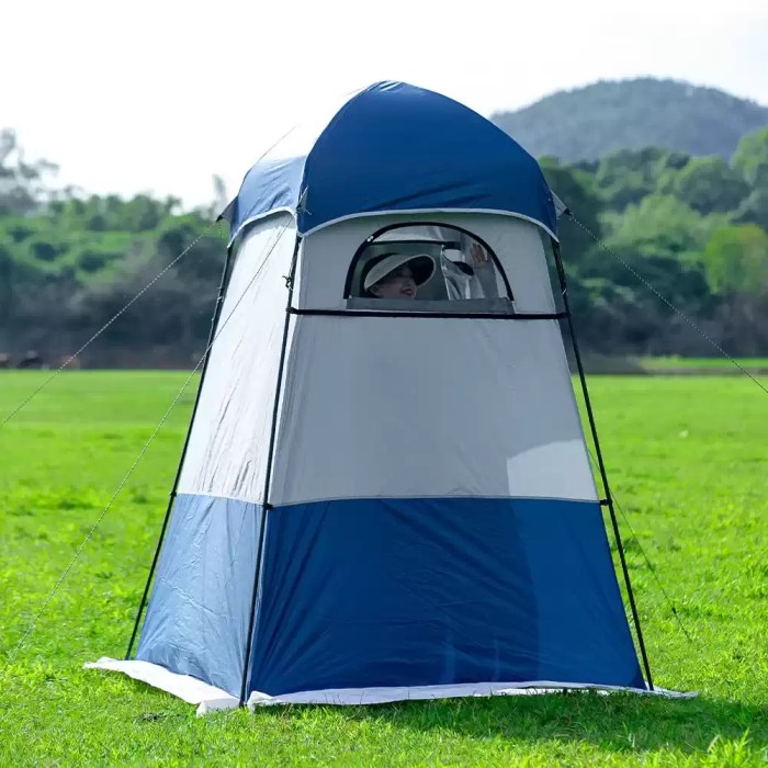 Tall camper standing inside the 240cm shower tent to show headroom.
