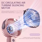 A blue mini portable fan placed on a camping table next to a tent for airflow.