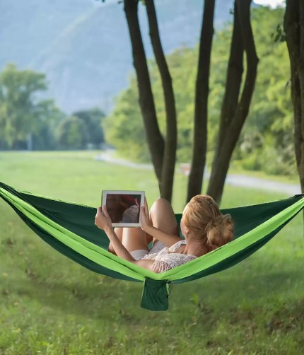A hiker relaxing in the 270x140cm parachute hammock during a travel break.