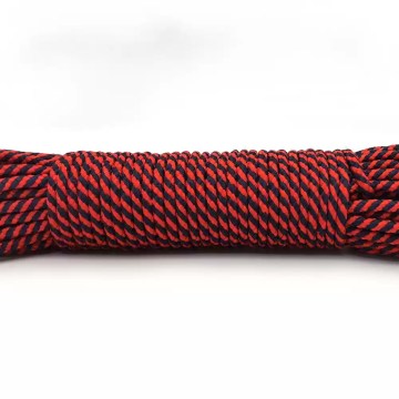 The 328ft lanyard rope coiled neatly next to a survival kit and camping cup.