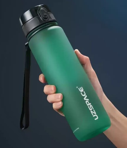 FJK Camping Gear water bottle shaker filled with fresh water on a trail.