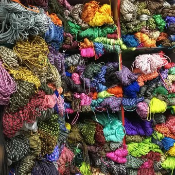 5m paracord coil being used to create a survival bracelet for climbing.