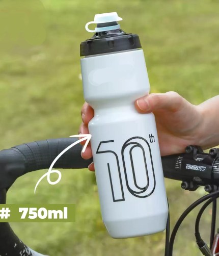 A 750ML sports bottle mounted on a mountain bike frame during a nature hike.