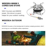 Portable gas stove boiling a large pot of water outdoors.