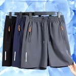 Men's athletic shorts featuring side zipper pockets with orange pulls, an elastic waistband, and reflective detailing, available in black, navy, and grey.