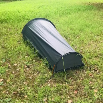 Solo traveler setting up the lightweight hiking tent in the forest.