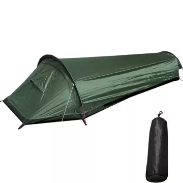 A green backpacking tent pitched on a grassy hill during a nature hike.
