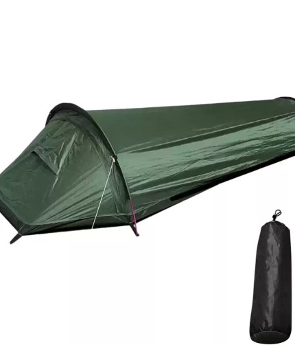 A green backpacking tent pitched on a grassy hill during a nature hike.
