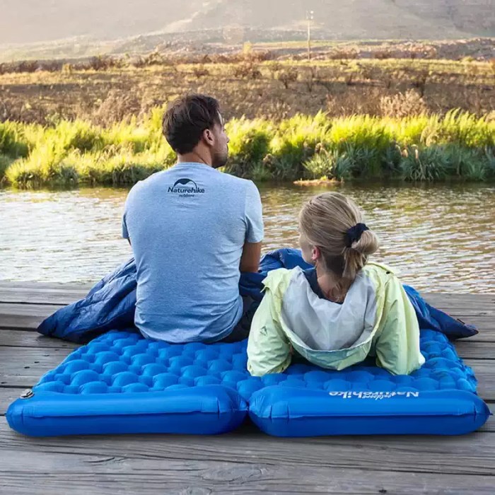 Alt Text: Top-down view of a camping sleeping pad with pillow featuring a blue honeycomb air-cell structure for back support.