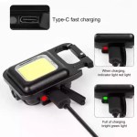 A compact black super bright mini COB keychain flashlight connected to a charging cable, showing a red indicator light during charging and a bright green light when fully charged.
