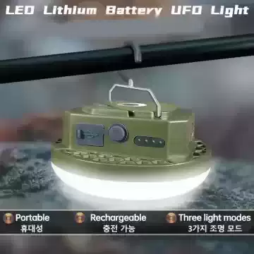 An olive green LED Lithium Battery UFO Light hanging from a hook on a rod, featuring a portable and rechargeable design with three light modes.
