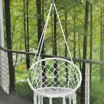 A woman relaxing in the woven hanging basket swing on a modern balcony.