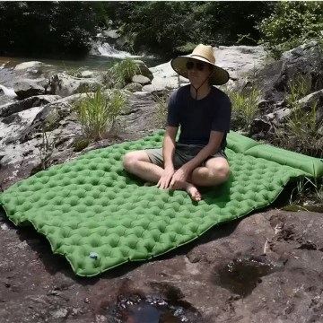 A couple sleeping on the queen size air bed inside a large family camping tent.