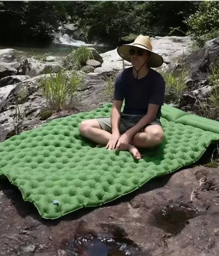 A couple sleeping on the queen size air bed inside a large family camping tent.