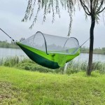 A hiker sleeping securely inside the bug-proof hanging bed during a nature hike.