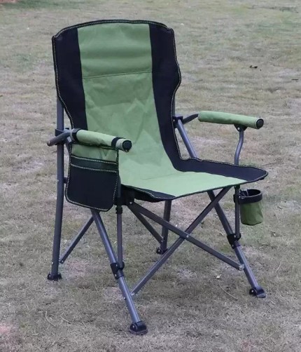 A person folding the high back chair into its black carry bag for transport.