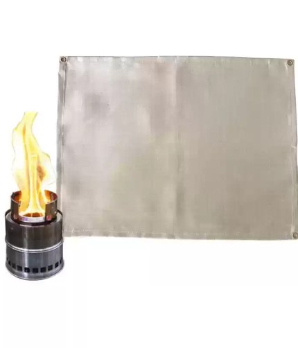 Portable fire blanket folded into a small square being tucked into a camping storage bag.