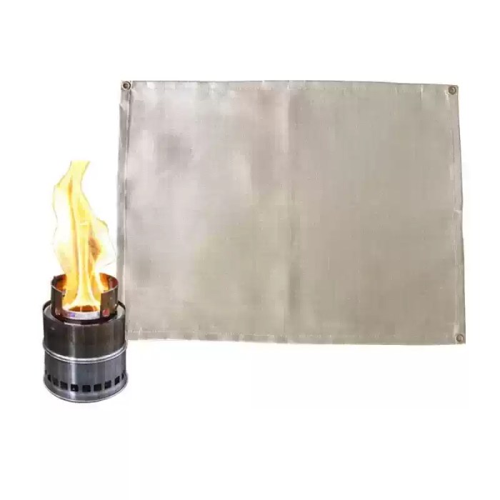 Portable fire blanket folded into a small square being tucked into a camping storage bag.