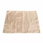 Close-up of the silver heat-reflective coating and reinforced edges of a professional fire pit mat.