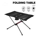 Portable folding camping table in black with two cup holders shown on a sandy beach.