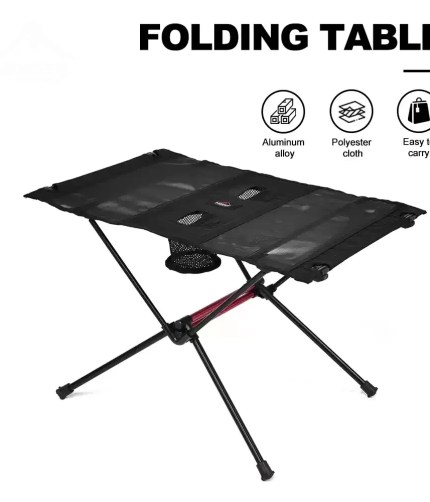 Portable folding camping table in black with two cup holders shown on a sandy beach.