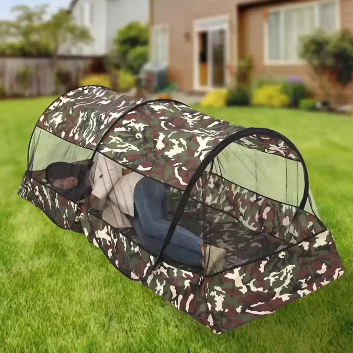 1-2 person camping mesh tent set up in a green forest for summer hiking.