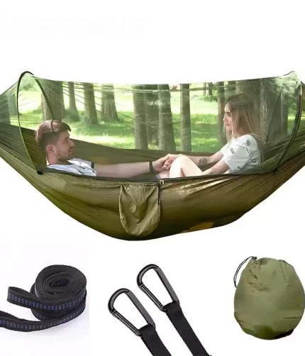 A man sleeping in the pop-up mosquito net hammock during a hiking trip.