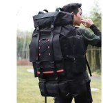 A man carrying a 130L large camping bag on a steep mountaineering trail.