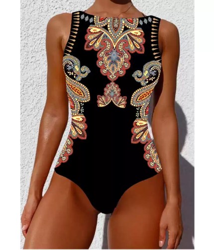 Model wearing a black one-piece swimsuit featuring an ornate bohemian paisley pattern.