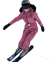 Pink Women’s One-Piece Ski Suit Woman skiing in a pink insulated one-piece ski suit