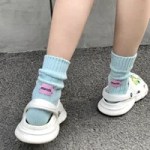 Colourful striped knitted crew socks worn with casual shoes
