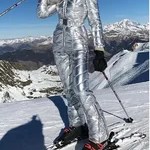 Woman wearing a silver metallic ski suit on snowy slopes