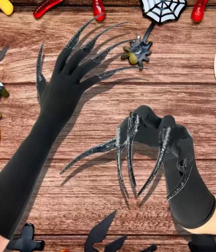 Long black claw costume gloves on Halloween decorated background