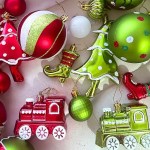 Assorted red and green Christmas tree baubles and train ornaments.