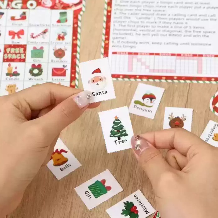 Close-up of hands holding festive Christmas bingo calling cards.