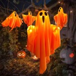 Orange LED glowing ghost hanging decoration in an outdoor Halloween setting.