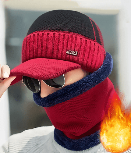 Men's red and black knitted peak cap with a "JEANS new wear" patch and a matching red and blue neck warmer worn by a model.
