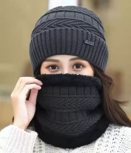 Women's dark grey cable-knit winter beanie and matching fleece-lined neck warmer set with a branded patch
