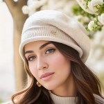 White knitted slouchy beanie hat featuring a classic ribbed cuff and branded metal hardware against a backdrop of white spring blossoms.