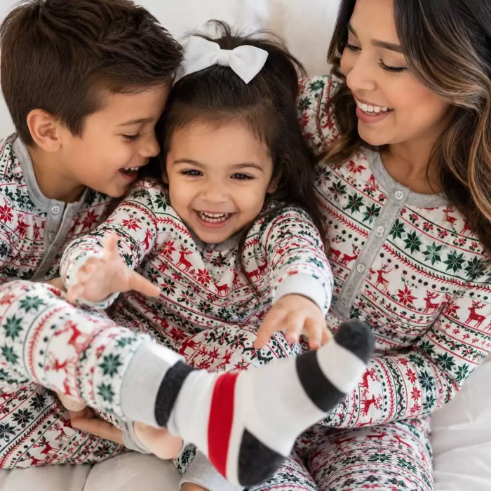 Close up of mother cuddling kids in matching Christmas sleepwear