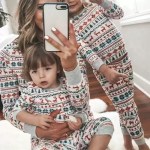 Mother and children taking selfie in matching reindeer Christmas pajamas