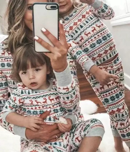 Mother and children taking selfie in matching reindeer Christmas pajamas