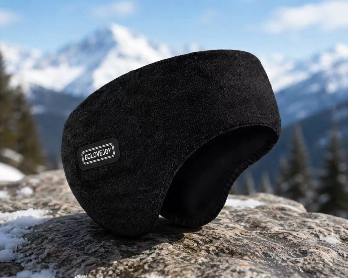 Thermal Ear Warmer Headband Black thermal ear warmer headband displayed on a snowy rock against a backdrop of mountains.